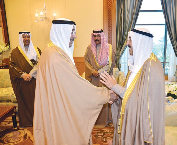 صاحب السمو الامير الشيخ صباح الاحمد مصافحا الوزير احمد الجسار بعد ادائه اليمين الدستورية بحضور سمو ولي العهد وسمو رئيس الوزراء