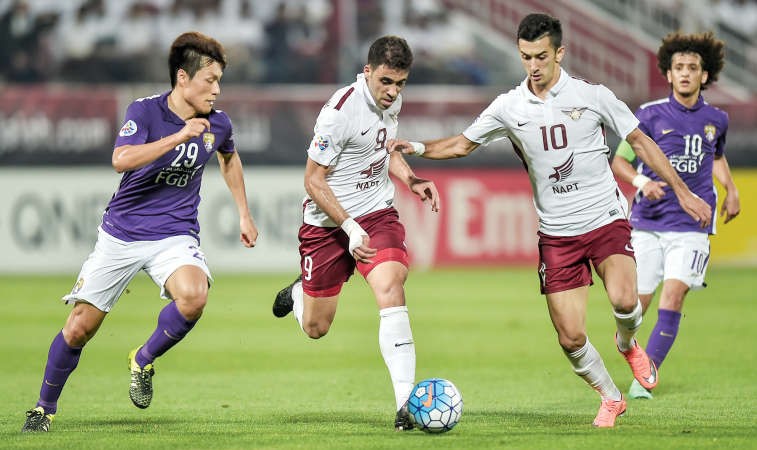 لاعب الجيش عبدالرزاق حمدالله يستخلص الكرة من مدافعي العين