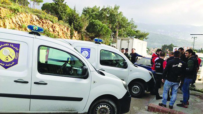 رجال وسيارات الشرطة والادلة الجنائية في موقع الجريمة