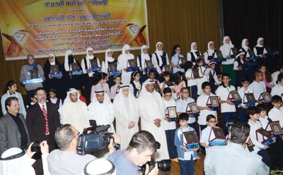 عبدالله البصري ود خالد المذكور يتوسطان الطلبة المكرمين خلال الحفل﻿