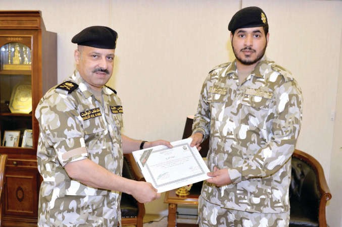 الامين العام المساعد لشؤون الحرس اللواء خالد الوقيت يسلم احد الخريجين شهادته﻿