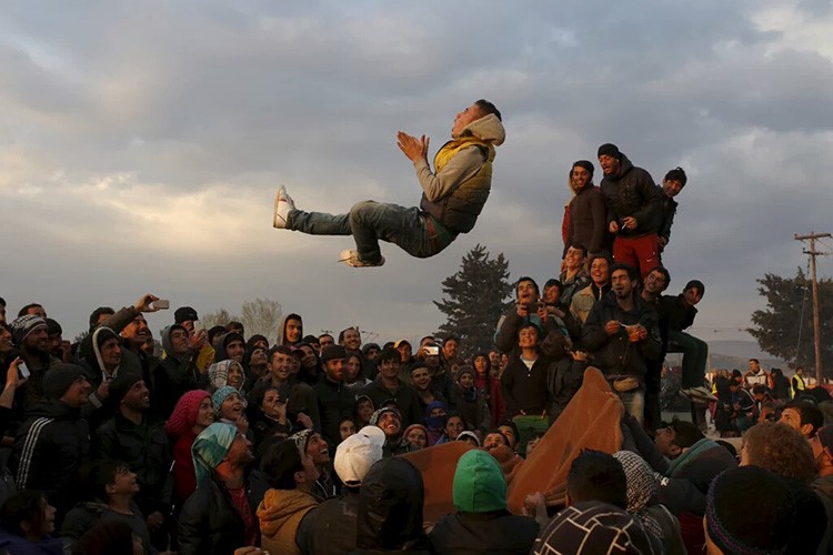 لاجئون يحاولون التخفيف من معاناتهم باللعب والمرح عند الحدود اليونانية - المقدونية