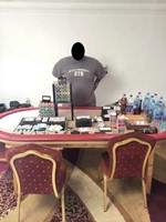 الاميركي المتهم امام اوراق اللعب والنقود المضبوطة