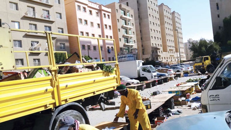 عمال البلدية اثناء نقلهم الاطعمة التالفة