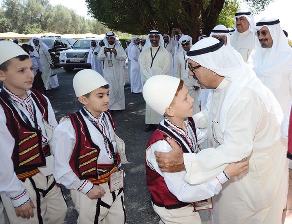 وزير شؤون الديوان الاميري الشيخ ناصر صباح الاحمد مصافحا احد الايتام في ملتقى الايتام السابع للعام 2016 بمزرعته في منطقة الصليبية