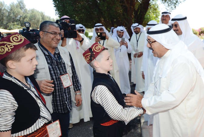 الشيخ ناصر صباح الاحمد مصافحا احد الايتام 