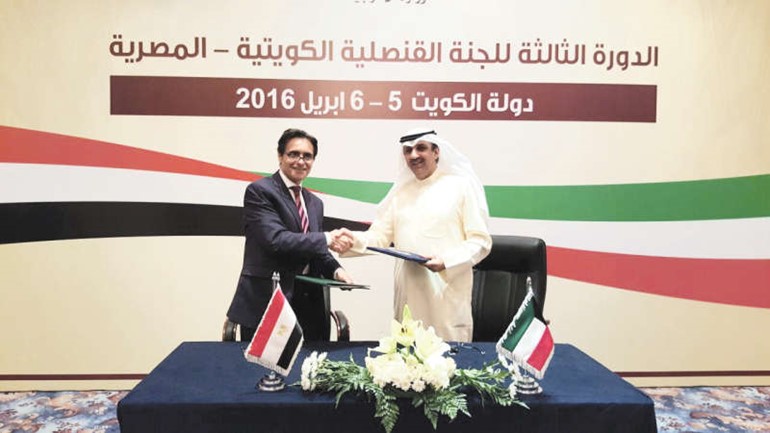 الوزير المفوض سامي الحمد ومساعد وزير الخارجية للشؤون القنصلية والمصريين في الخارج هشام النقيب يتبادلان بنود الاتفاق﻿