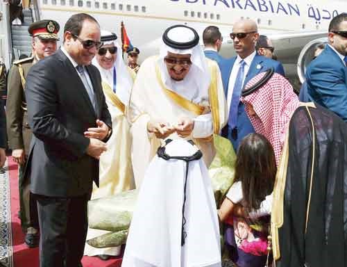 خادم الحرمين الشريفين ملاطفا طفلين قدما له الزهور لدى وصوله الى مطار القاهرةرويترز