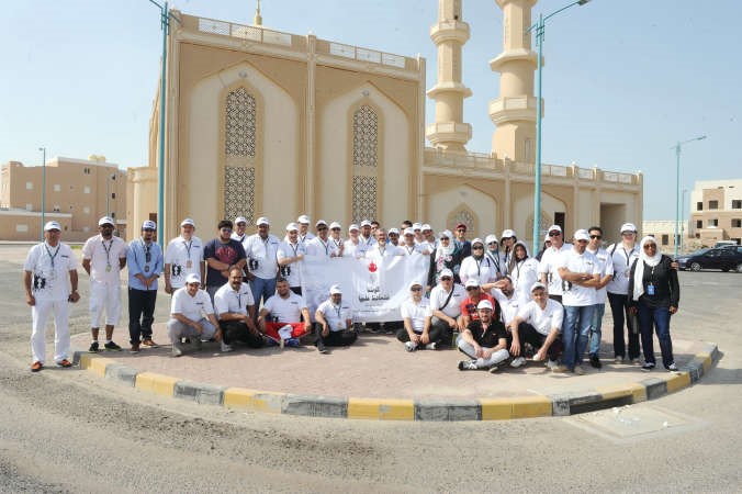 المشاركون في حملة تنظيف شاطئ مدينة صباح الاحمد البحرية في لقطة تذكارية امام مسجد المغفور له باذن الله تعالى وليد خالد المرزوقهاني الشمري﻿