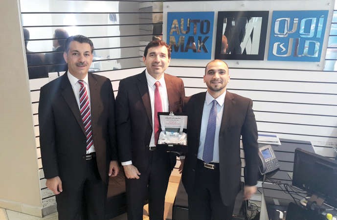 عبدالله مؤذن المدير التنفيذي للمبيعات في شفروليه الغانم مع مسؤولي اوتوماك خلال توقيع الاتفاقية