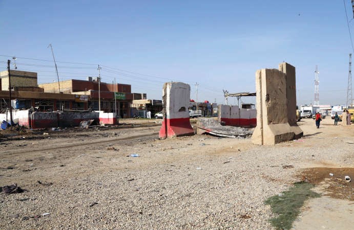 ﻿اثار تفجير السيارة المفخخة بادية على احد حواجز بغداد امس الاولافپ﻿