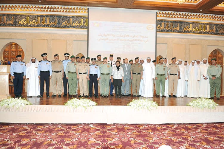 الفريق الركن مهاشم الرفاعي ودموضي الحمود يتوسطان عددا من المشاركين في الندوة احمد علي