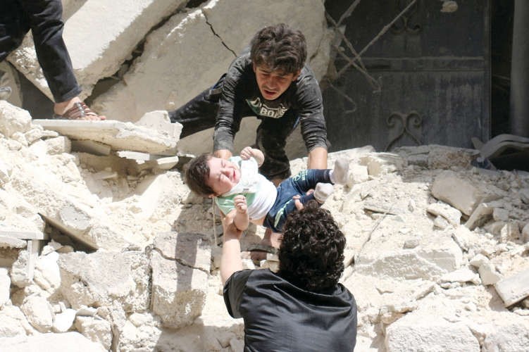 انقاذ رضيع سوري من تحت انقاض مبنى استهدفته غارة في حلب امس الاول افپ