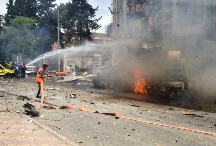 صورة وزعتها وكالة الانباء السورية سانا لمواطنين ورجال اطفاء يخمدون النيران بعد تعرض مستشفى الضبيط للقصف في حلب امس اپ