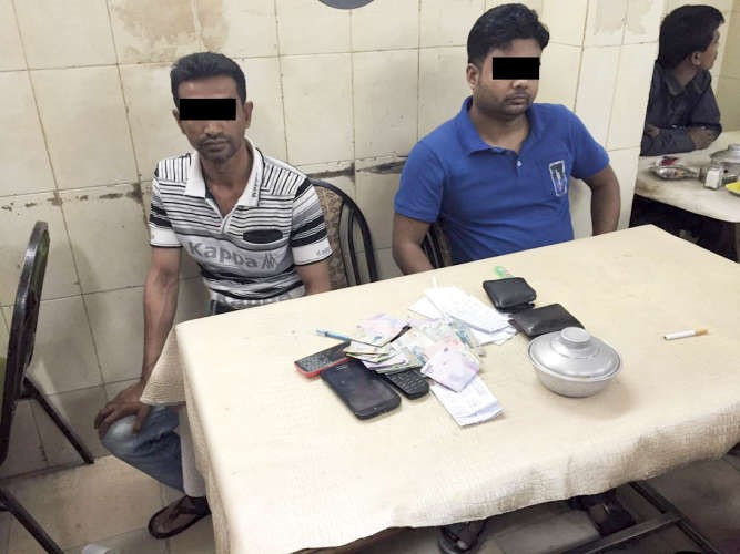 الاسيويان وامامهما اوراق اللعب والمال المتربح من القمار﻿