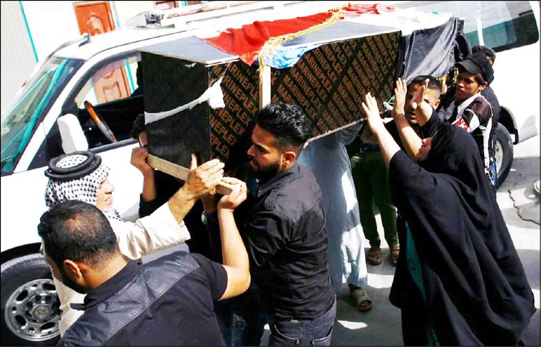 اقارب احد ضحايا تفجير مدينة الصدر يحملون جثمانه خلال تشييعه امسافپ