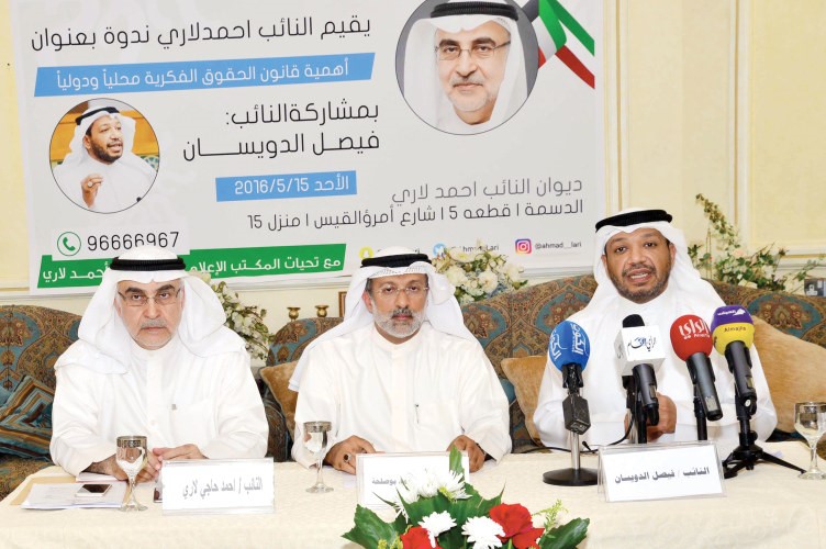 فيصل الدويسان واحمد لاري يتوسطهما عريف الندوة