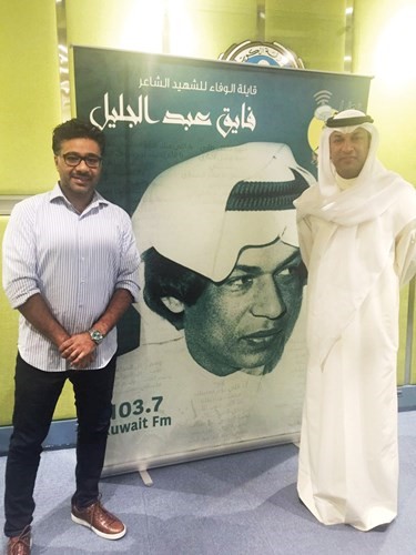 فارس مع صورة والده الشاعر الشهيد فايق عبدالجليل﻿
