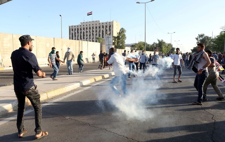 متظاهرون من انصار الصدر يقاومون الغاز المسيل للدموع عقب اقتحامهم المنطقة الخضراء امس رويترز 