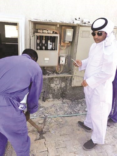 العامل الفني يقوم بمهمته في قطع التيار عن احد البيوت المخالفة