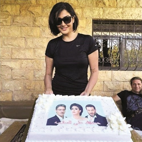 غادة وامامها قالب كيك احتفالا بشفائها