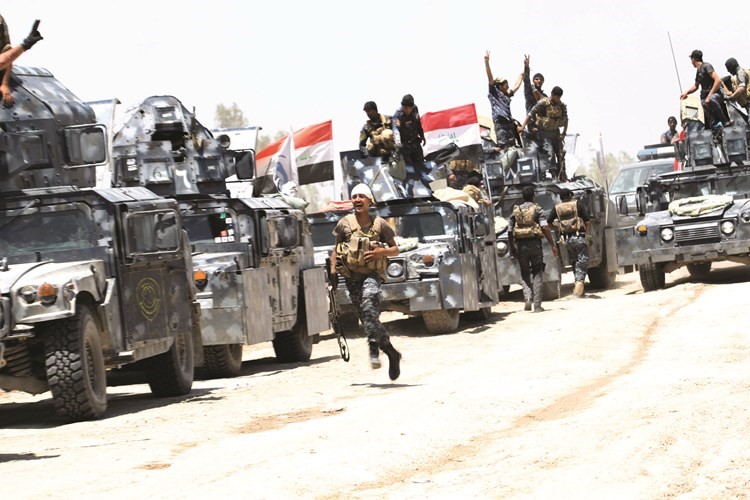 جنود من القوات الموالية للجيش العراقي فوق مدرعاتهم خلال معركة تحرير الفلوجة امس	 رويترز﻿