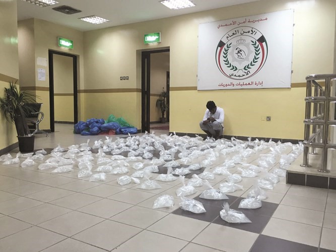 الوافد الاسيوي وامامه المضبوطات من الخمور﻿