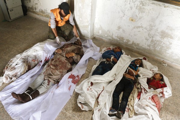 سوري يعاين جثث رجلين و3 اطفال سقطوا ضحية الغارات في حلب امس 	افب