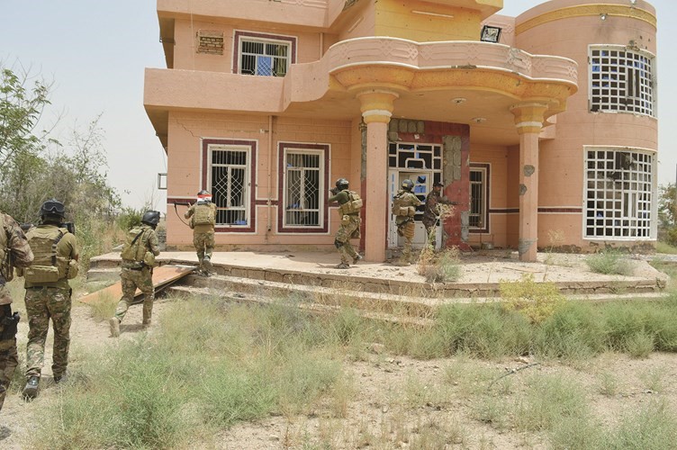 افراد من قوات الامن العراقية في طريقهم لتفقد احد المنازل جنوب الفلوجة امس الاول 	رويترز﻿