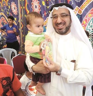 دالفليج يحمل طفلا من اطفال المخيمات
