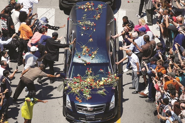 محبو الملاكم الاسطوري يلقون الزهور على السيارة التي حملت جثمانه امس الاول 	رويترز ﻿