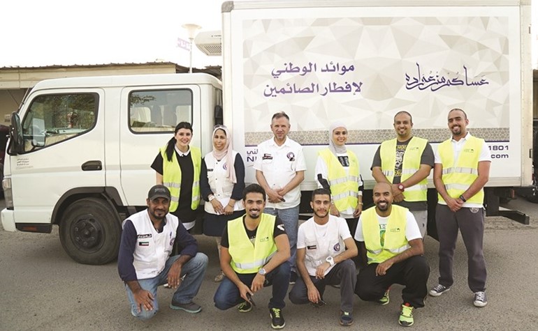 اسرة العلاقات العامة ومتطوعون من بنك الكويت الوطني خلال احدى الجولات الرمضانية الميدانية﻿