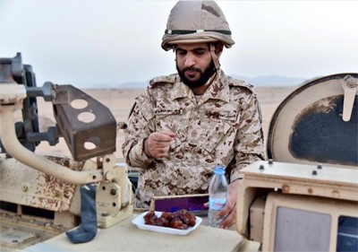 مغردون يتداولون صورة لجندي سعودي بالحد الجنوبي يتناول إفطاره فوق مدرعة