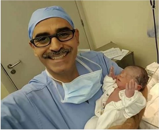 صورة.. طبيب يلتقط "سيلفي" مع مولود رفع يده كأنه يدعو