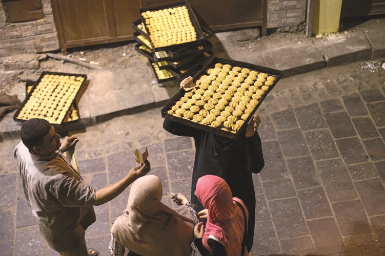 الذهاب بصواني الكعك الى المخبز فرحة للكبار والصغار بعيد الفطر 
