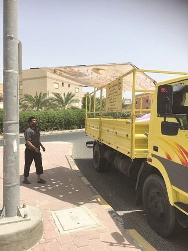 عمال البلدية يزيلون احد الاعلانات المخالفة