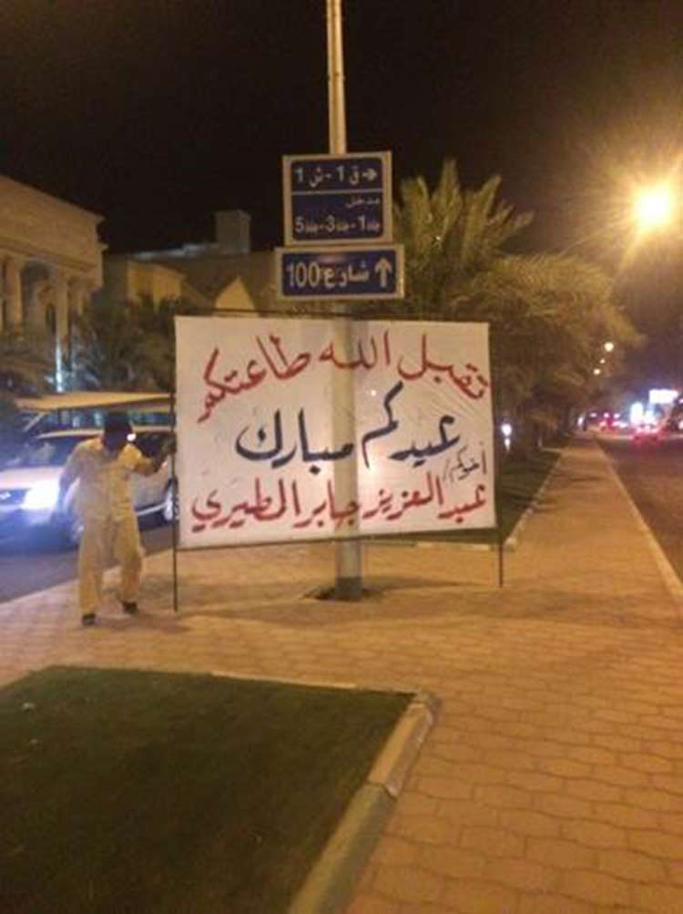 عامل البلدية يزيل احد الاعلانات المتعلقة بتبريكات العيد