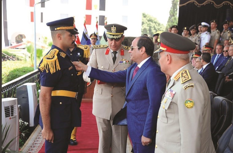 الرئيس السيسي خلال تكريمه احد اوائل خريجي الكلية الحربية امس 