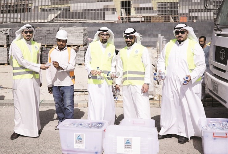 موظفو الدولي خلال توزيعهم المرطبات على العمال