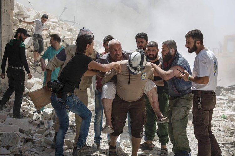 مدنيون سوريون ينقذون عجوزا مصابا اخرجوه من تحت الانقاض اثر قصف بالبراميل المتفجرة على حلبافپ﻿
