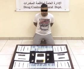 المتهم وامامه المضبوطات