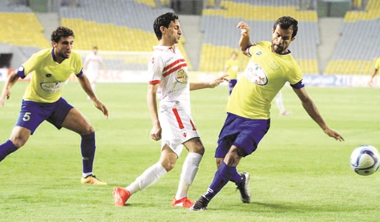 نجم الزمالك ايمن حفني يمرر الكرة رغم مضايقة دفاع الاسماعيلي