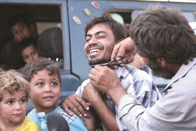 احد سكان منبج يحلق لحيته بعد خروجه من منبجرويترز 