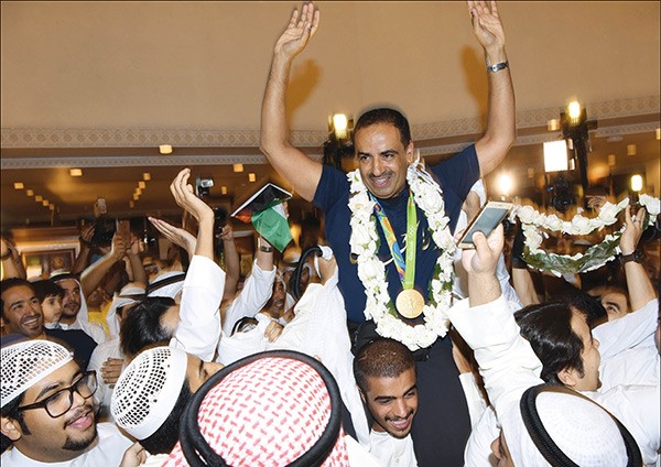 البطل الذهبي فهيد الديحاني على اكتاف محبيه لدى وصوله ارض الكويت 	احمد علي - محمد هاشم