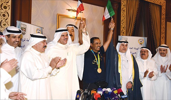 البطل فهيد الديحاني متوسطا رئيس مجلس الامة بالانابة عبدالله التميمي والوزير الشيخ سلمان الحمود وعددا من مستقبليه وفي الاطار البطل محمولا على الاكتاف	 محمد هاشم - احمد علي