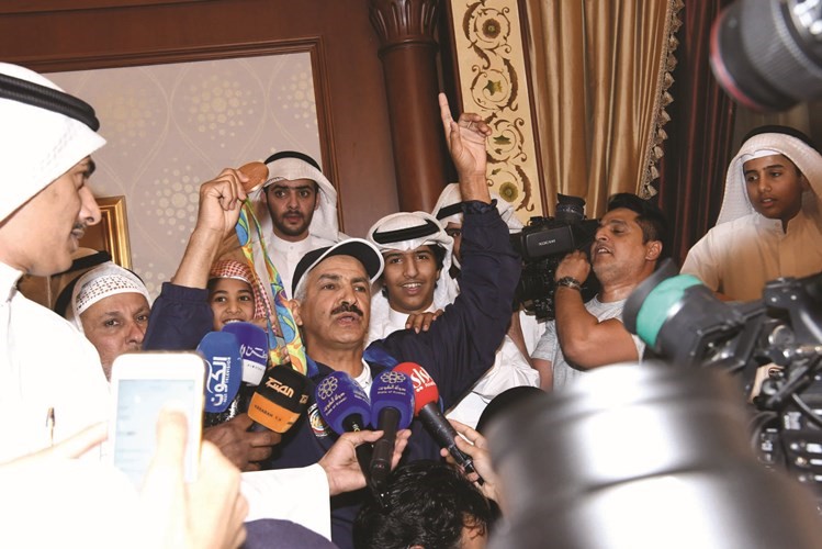 عبدالله الطرقي رافعا ميداليته الاولمبية وسط محبيه ومستقبليه في مطار الكويت امس