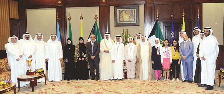صاحب السمو الامير وسمو ولي العهد يتوسطان دعدنان شهاب الدين واعضاء مركز صباح الاحمد للموهبة والابداع والطلبة الفائزين في المسابقة الدولية سمارت برين 