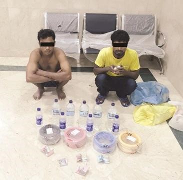 الوافدان وامامهما الكيبلات والخمور المضبوطة﻿