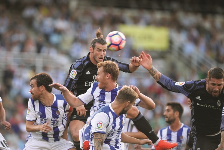 نجم ريال مدريد غاريث بيل يحول الكرة براسه وسط رقابة من مدافعي ريال سوسييدادرويترز