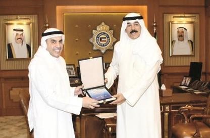 الشيخ محمد الخالد يتسلم نسخة الكتاب من د عبدالله الطريجي﻿